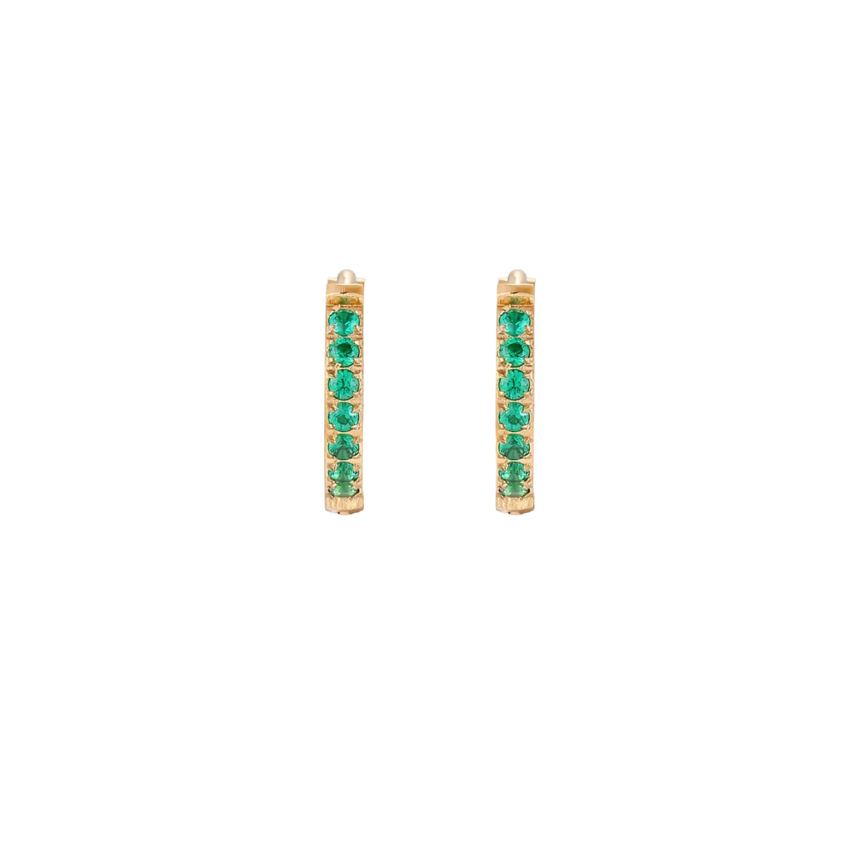 Pair of small gold huggie hoop earrings with bright green cubic zirconia stones on cream background