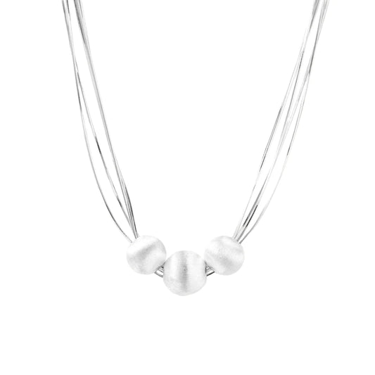 Sterling silver multi-strand necklace with three brushed round beads on cream background