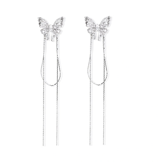 Pair of silver threader earrings with crystal butterfly tops and long chain drops on cream background.