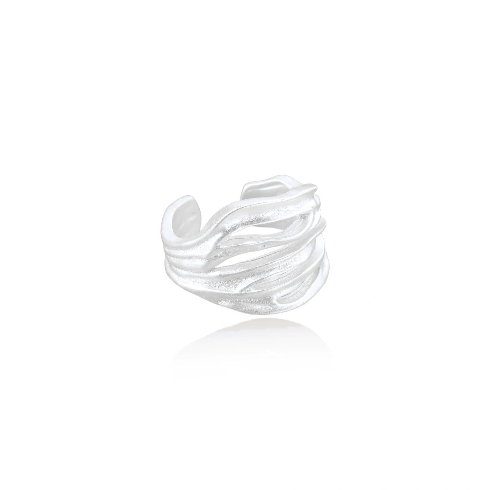 Wide sterling silver cuff ring with flowing wave patterns creating dimensional texture against cream background