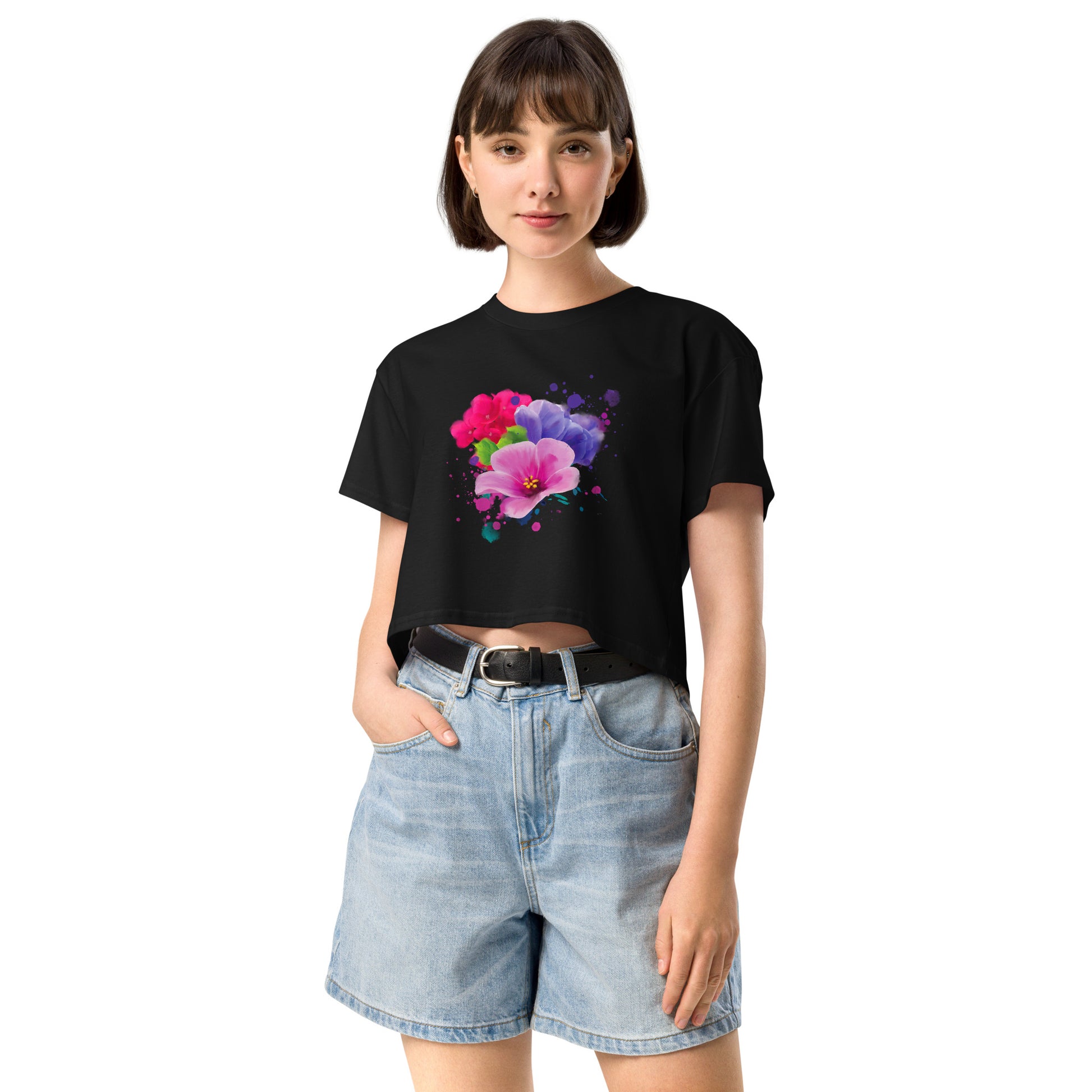 Person wearing a black t-shirt with a colorful floral design and denim shorts on a white background